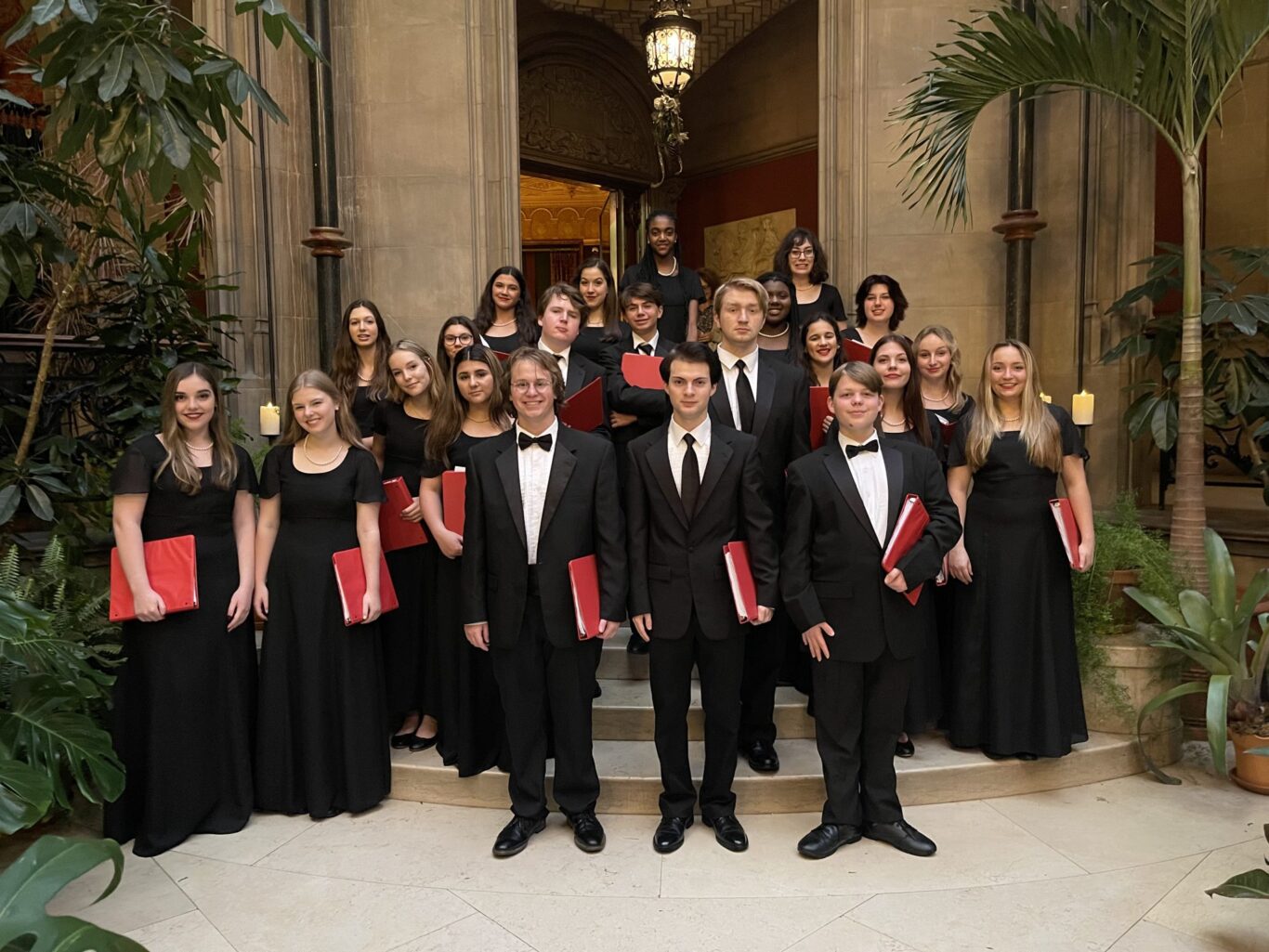 Members of the Prov Chorale, dressed in black tuxedos, posing for a photo at Carnegie Hall.