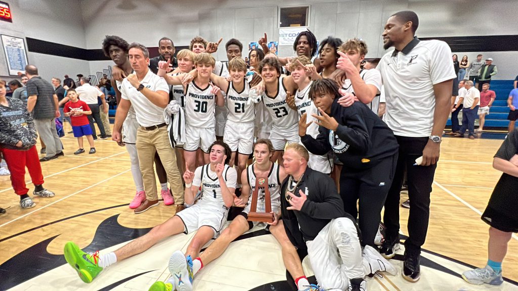 A group of boys' basketball players posing for a picture at a state tournament.