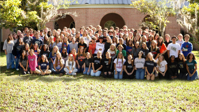 A group of people from the Class of 2023 celebrating in front of a building.