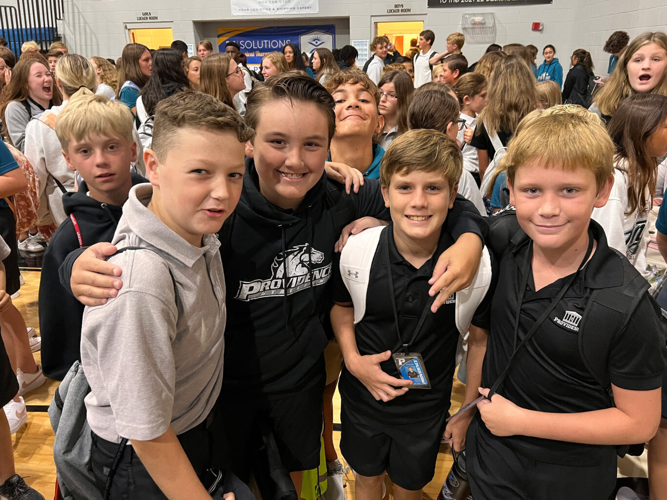 A group of kids posing for a picture in a gym.