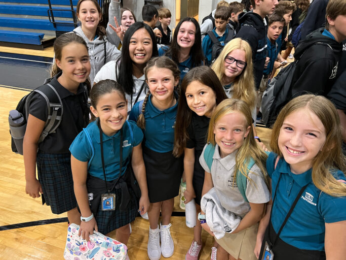 A group of girls posing for a picture in a gym.