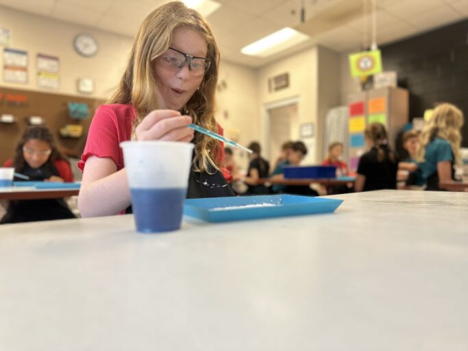 A girl in a lower school classroom is working on a project for Steam Discovery.