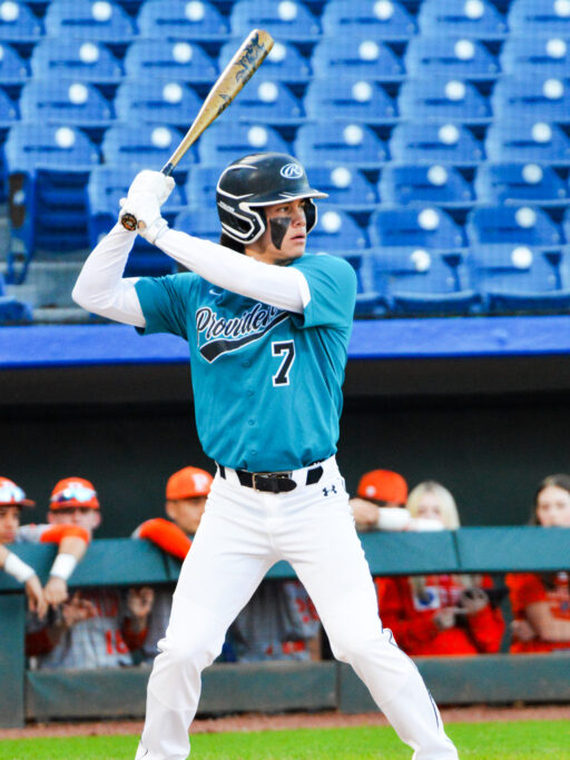 A baseball player demonstrating their swing on a baseball field.