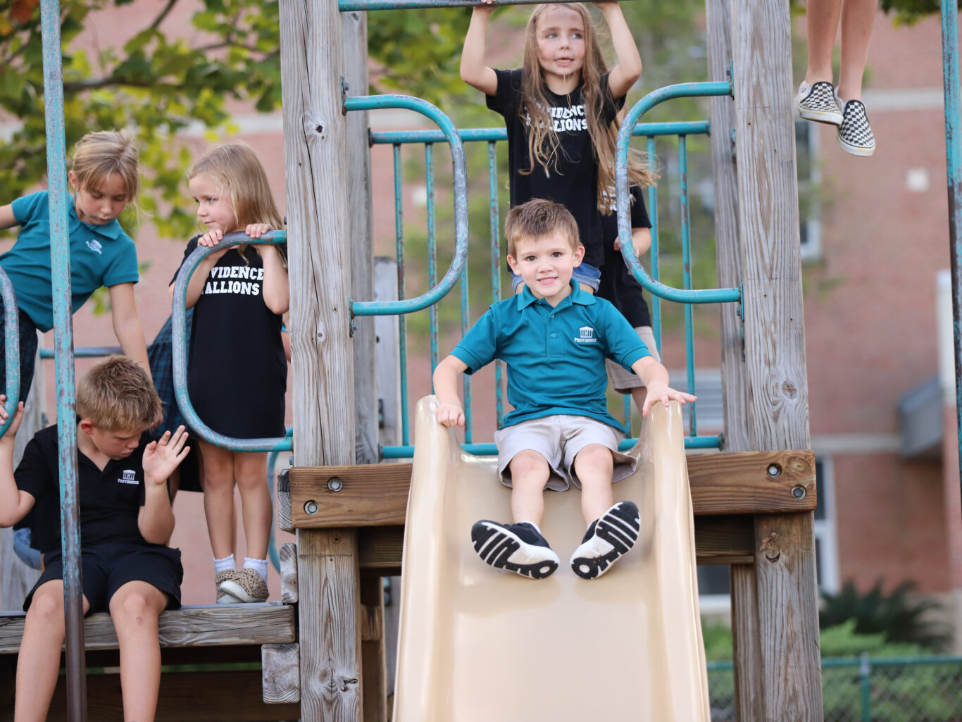 A group of children demonstrating leadership skills on a playground slide.