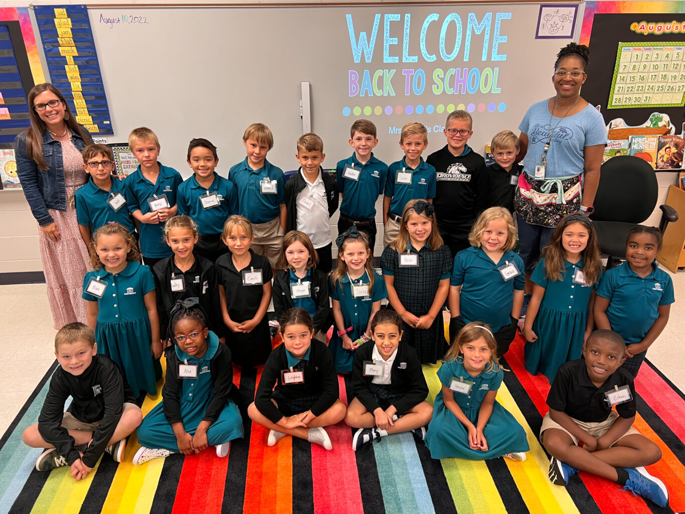 A group of children displaying leadership by posing for a photo in a classroom.