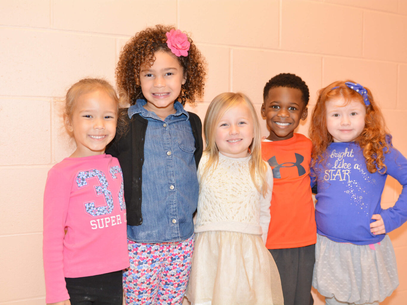 A preschool group posing for a picture with young children.