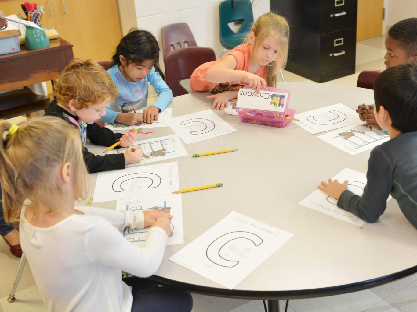 Preschool children sitting around a table.