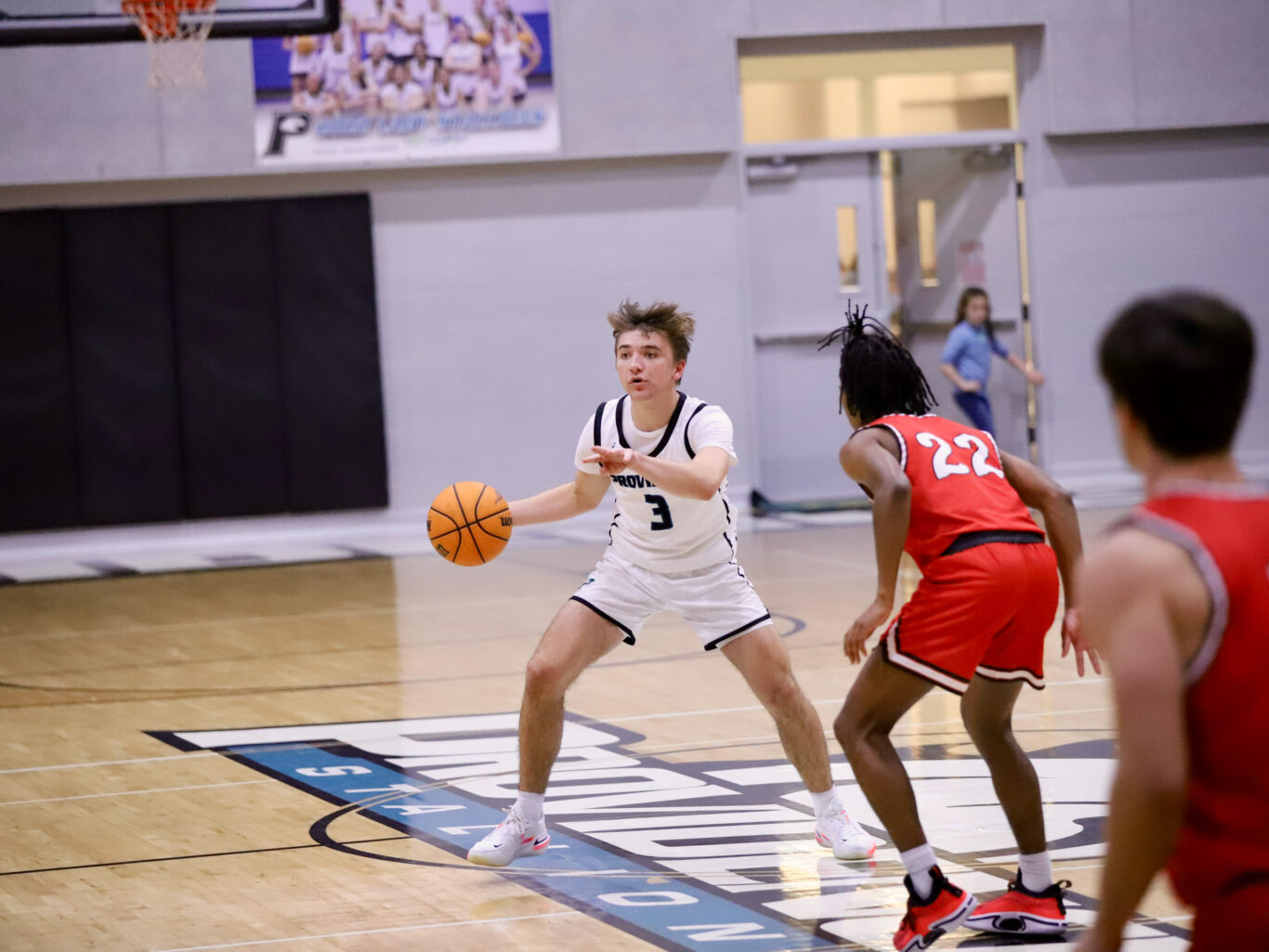 A young boy is playing basketball in a gym.