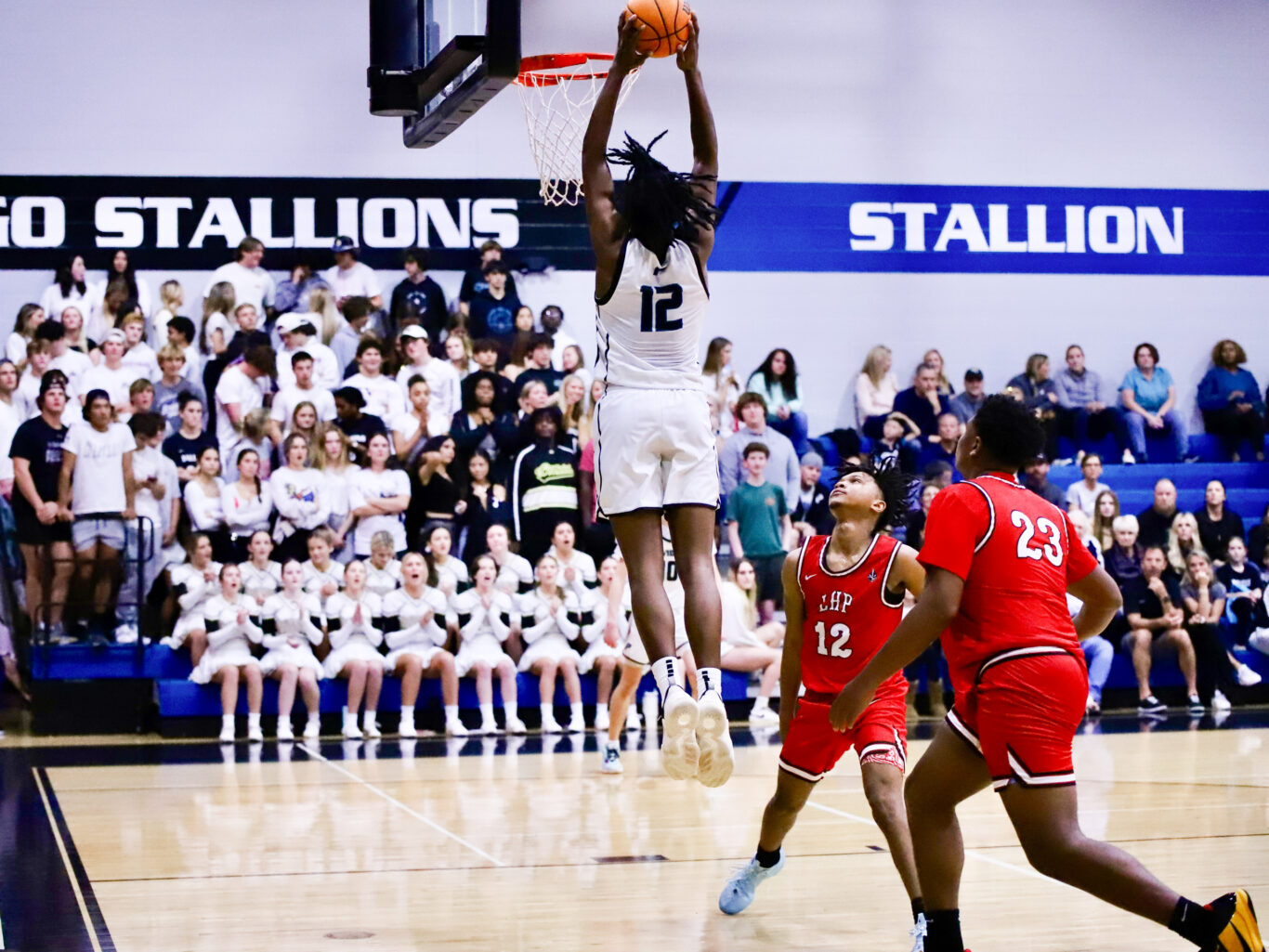 A basketball player, typically a boy, is about to dunk the ball.