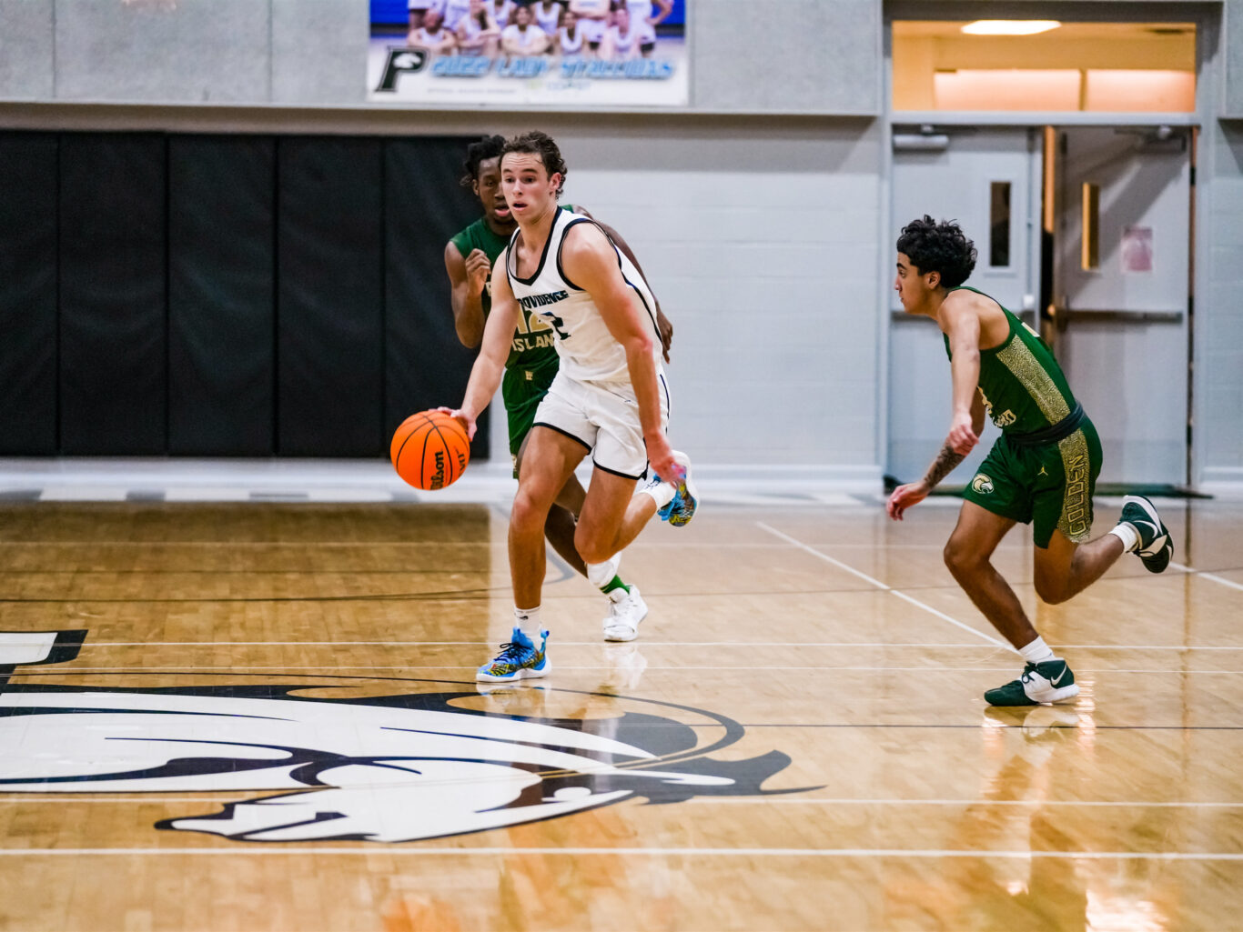 A basketball game with a boy dribbling the ball