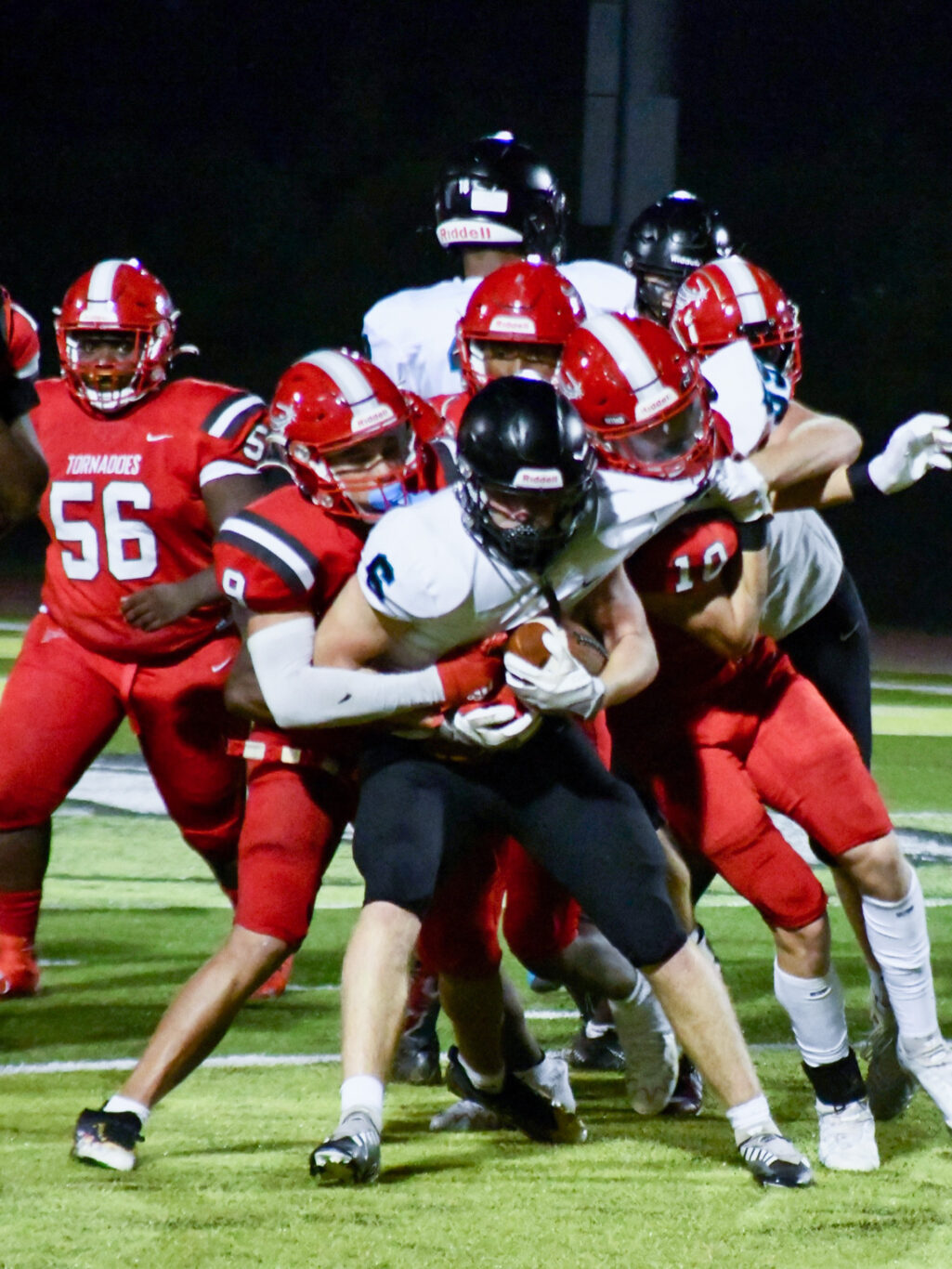 A football player is being tackled by other players.