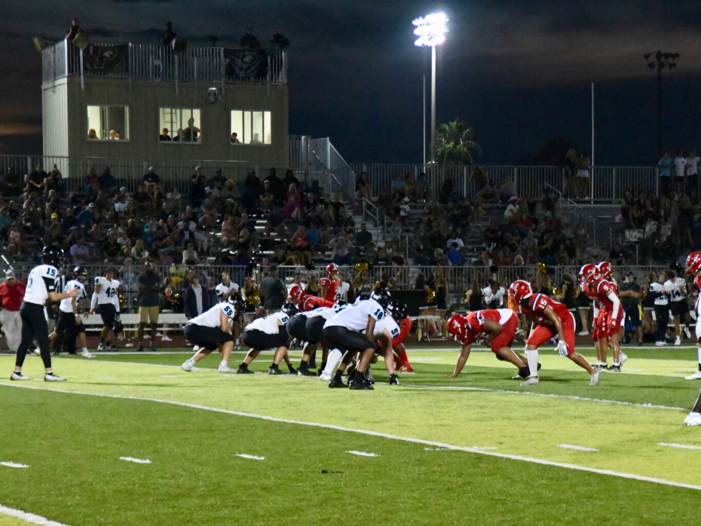 A thrilling football game played under the lights on a field at night.