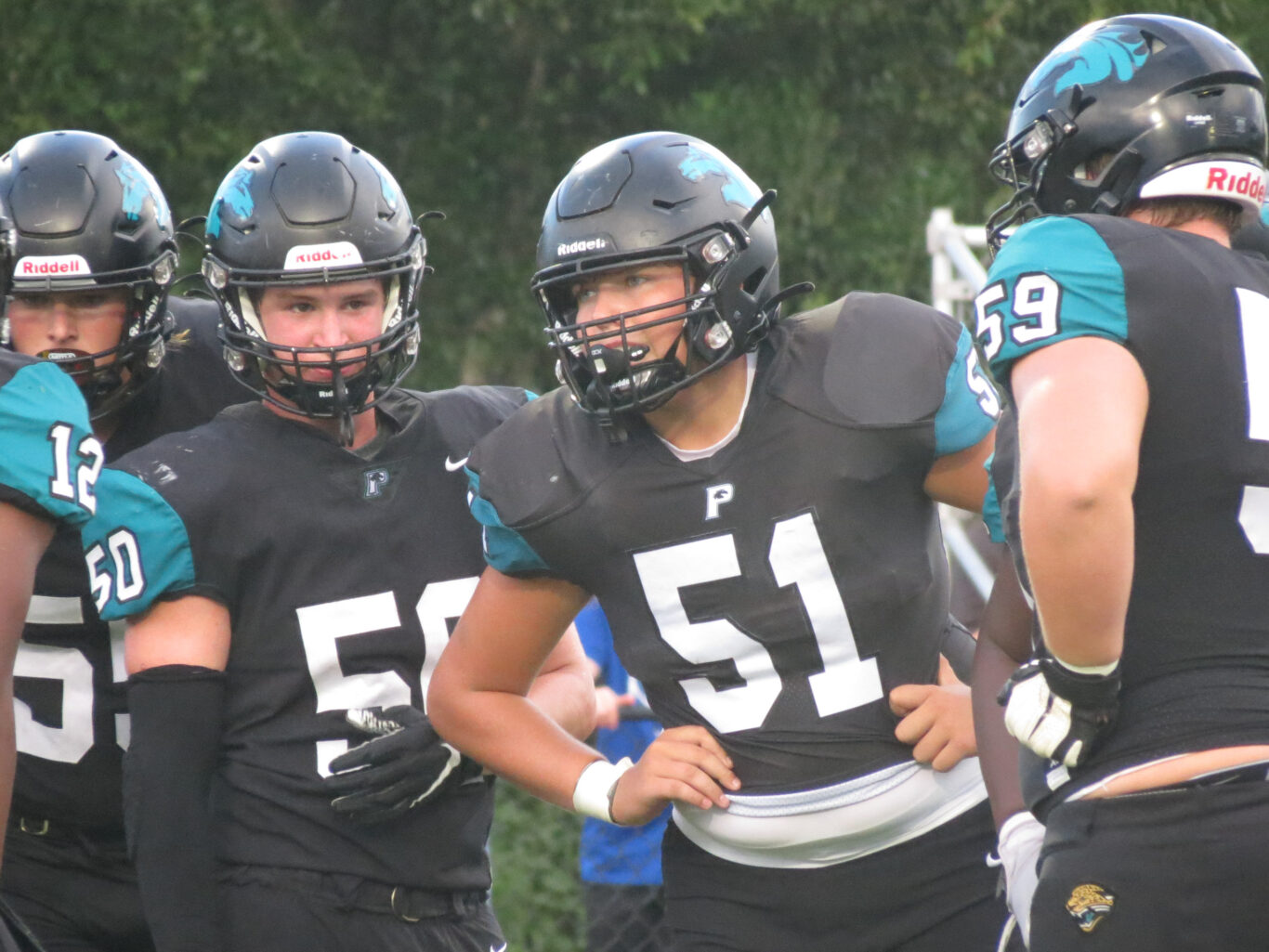 A group of football players standing together on the field during a game.