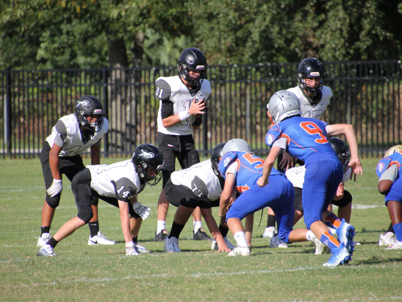 A group of football players on a field, engaged in intense gameplay.