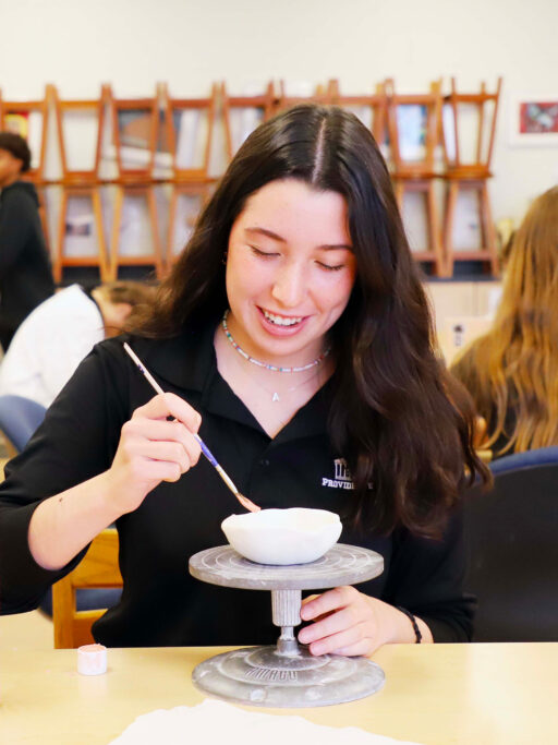 A girl is creating a masterpiece in a classroom, showcasing her talent for visual arts.