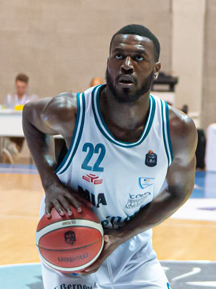 A College basketball player is dribbling the ball on a court.