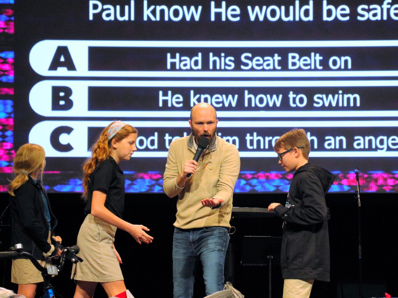 A group of important people standing on a stage with a microphone.