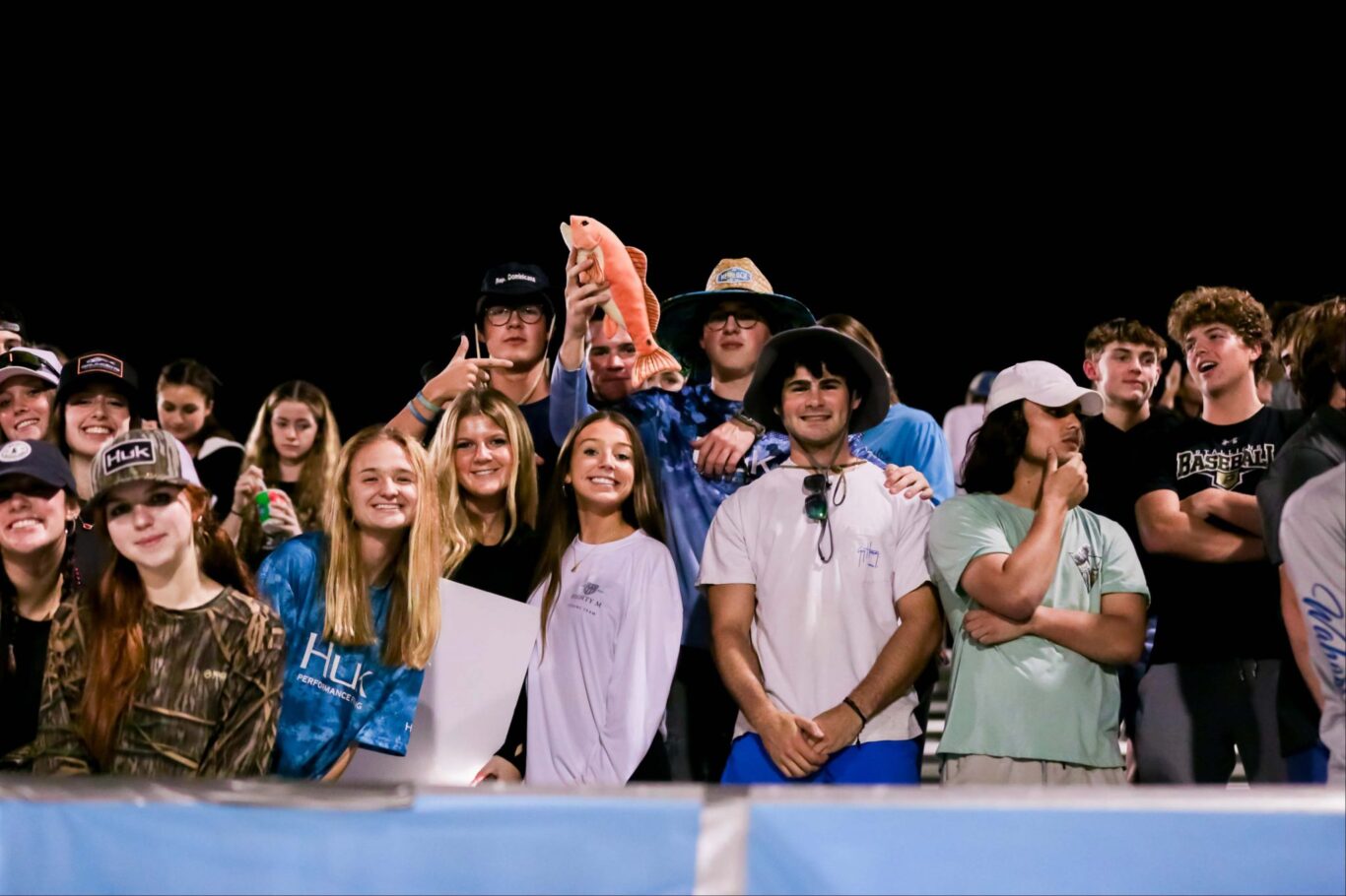 A group of people posing for a photo at a 2023 football game homecoming.