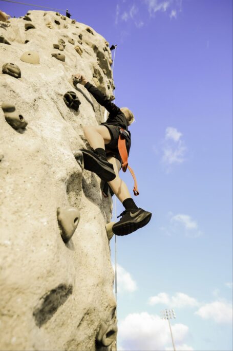 A person climbing a rock wall at the 2023 PTP Fall Festival.