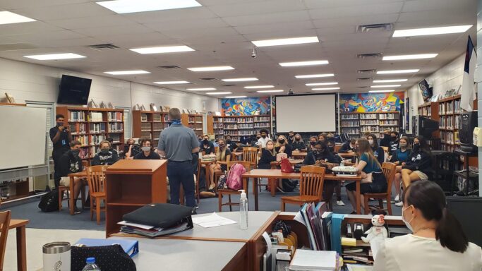 A group of people visits Providence, excited to listen to NY Times Bestselling Author, Charles Martin, speak in a classroom.