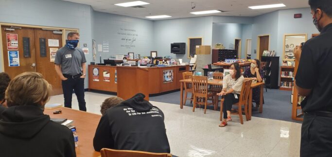 A group of people, including the NY Times Bestselling Author Charles Martin, sitting around a table in a library.