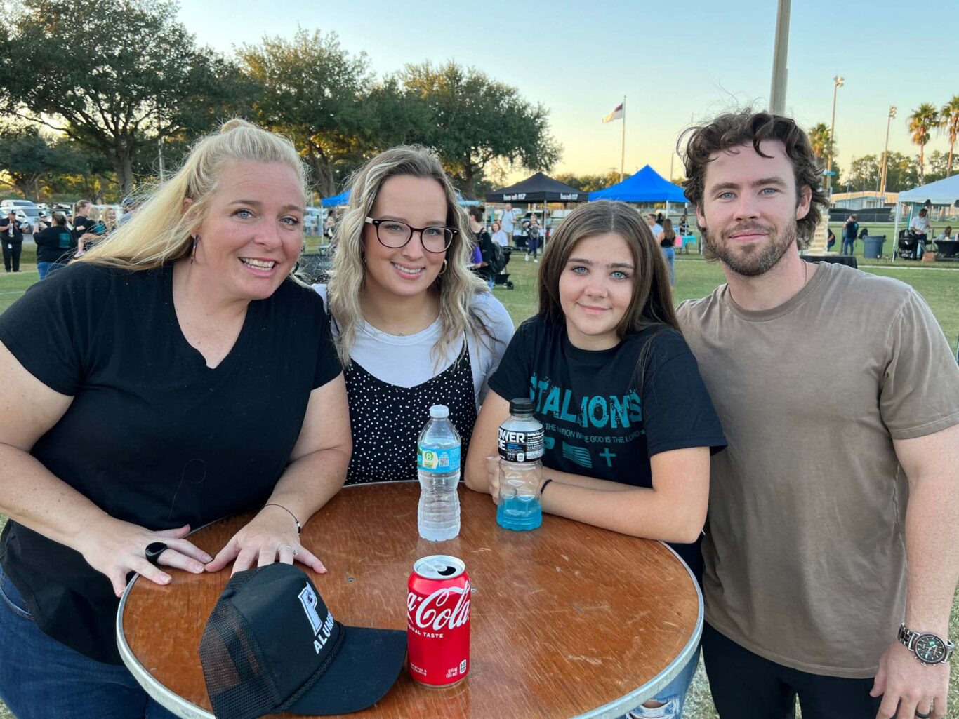 Four people posing for a photo at a 2023 outdoor event.