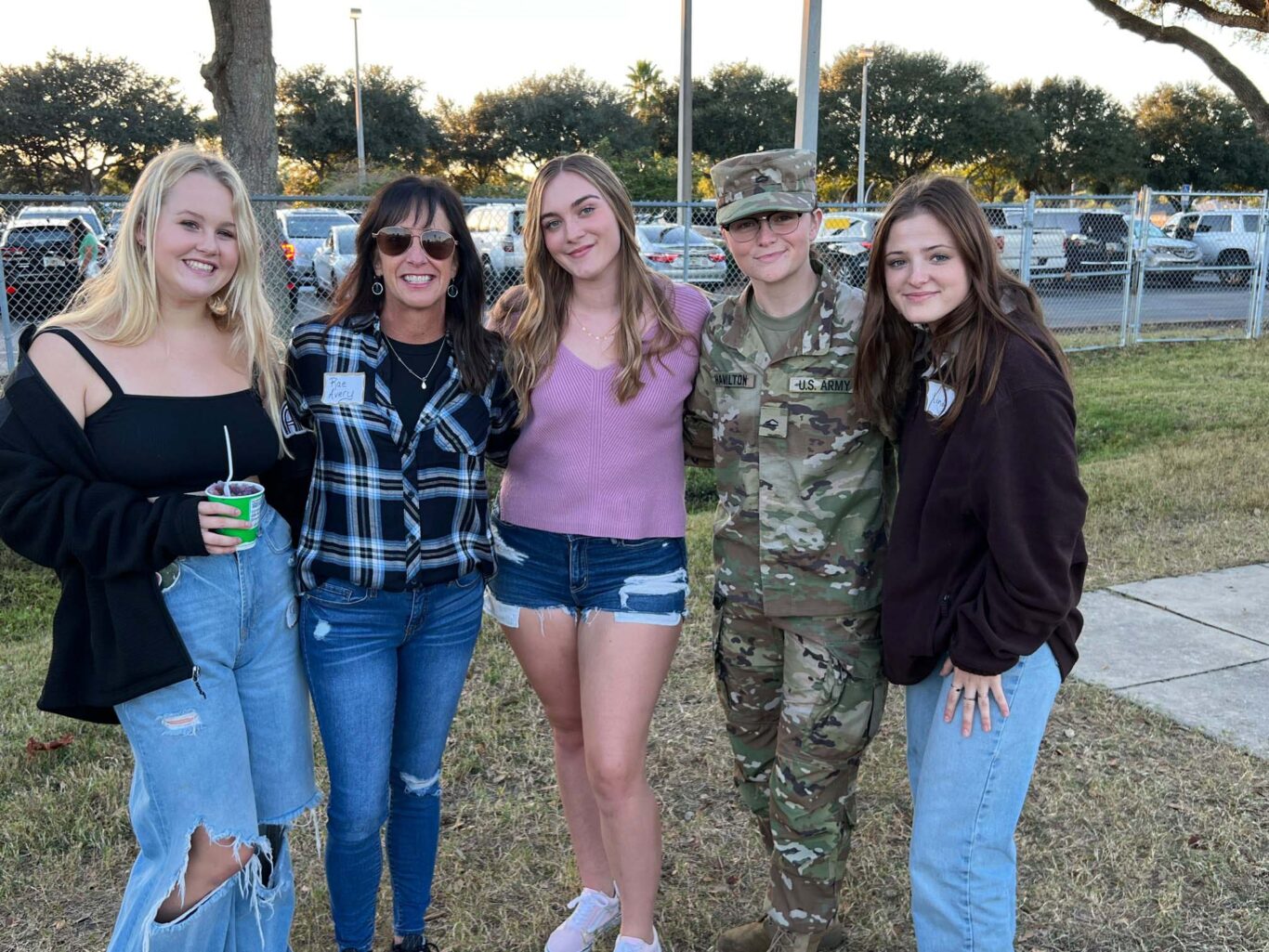 A group of girls posing for a photo with an army soldier at Homecoming 2023.