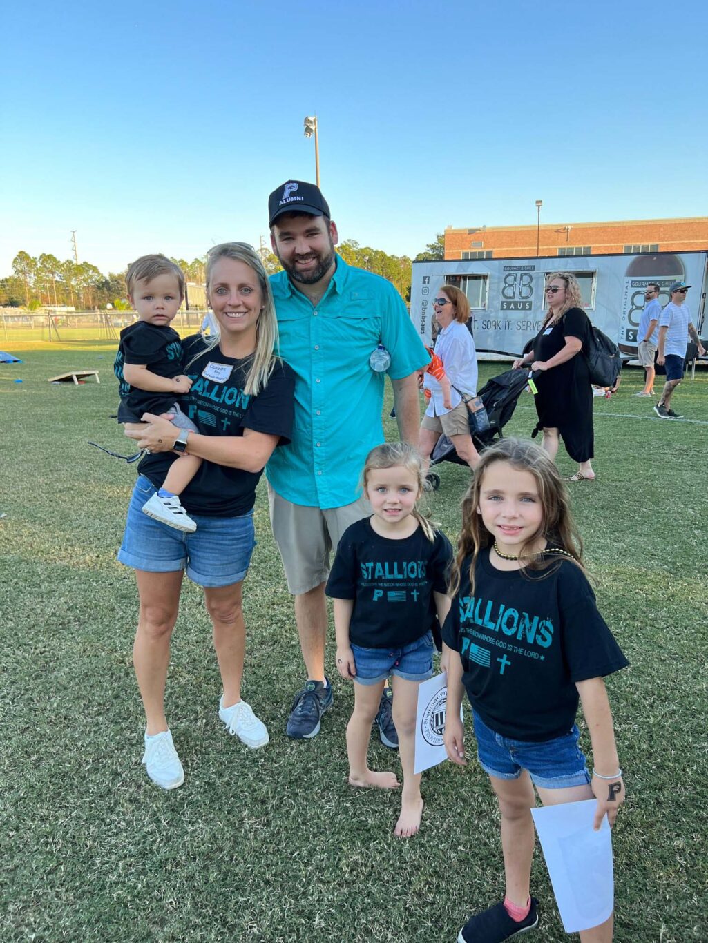 A family posing for a picture at the 2023 homecoming football game.