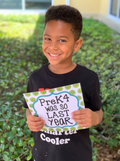 A preschool boy holding up a sign that reads pk4 was so last year.