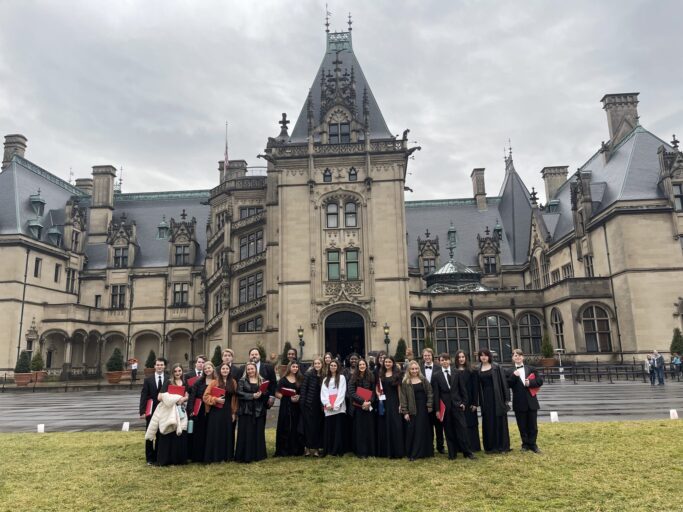Members of Prov Chorale posing in front of an ornate castle.