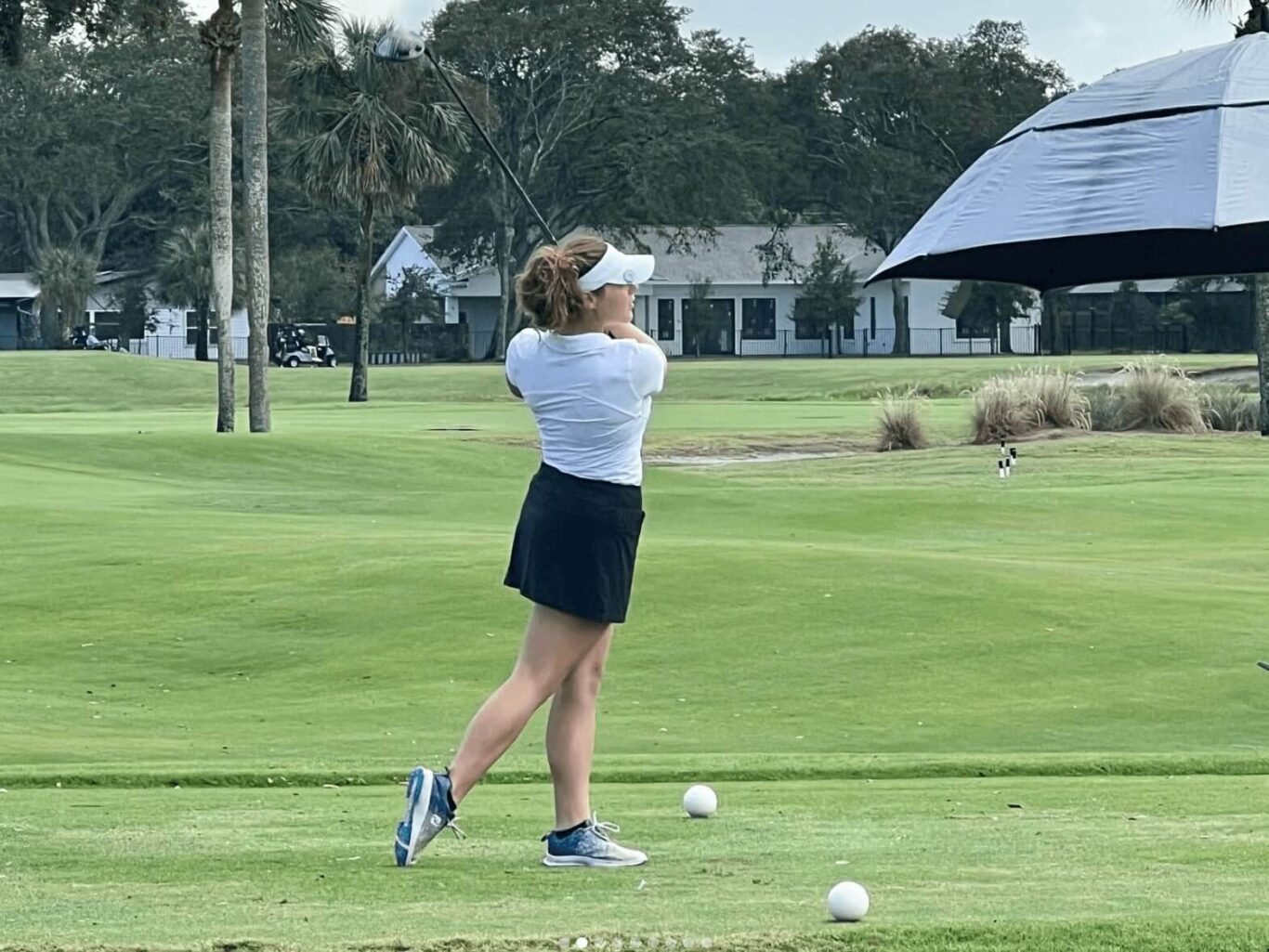 girl with a golf club post swing