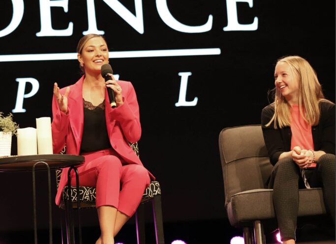 Two women sitting in chairs at a Special Chapel event focused on advocacy.