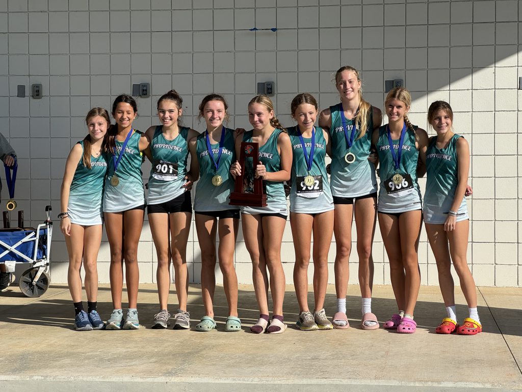 A group of cross country girls posing with their trophies after winning districts.