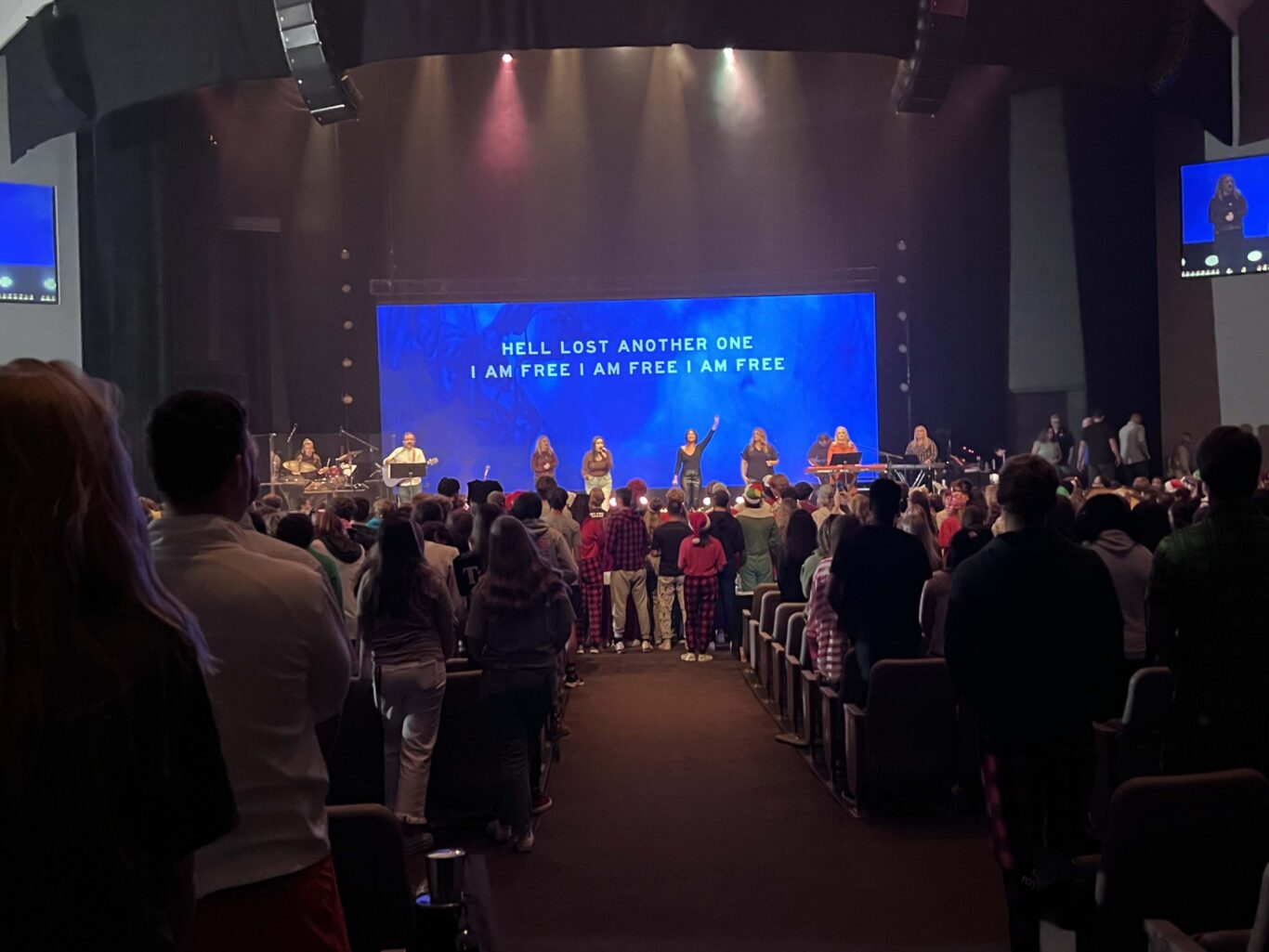 A group of people standing in a church auditorium, celebrating Homecoming 2023.