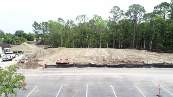 An aerial view of a construction project with trees in the background.