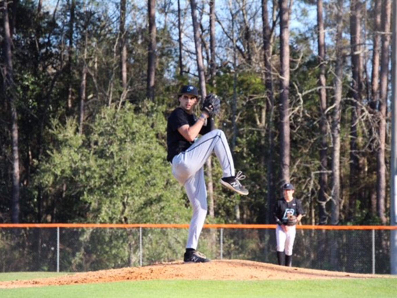 A baseball player is pitching a ball on a baseball field.