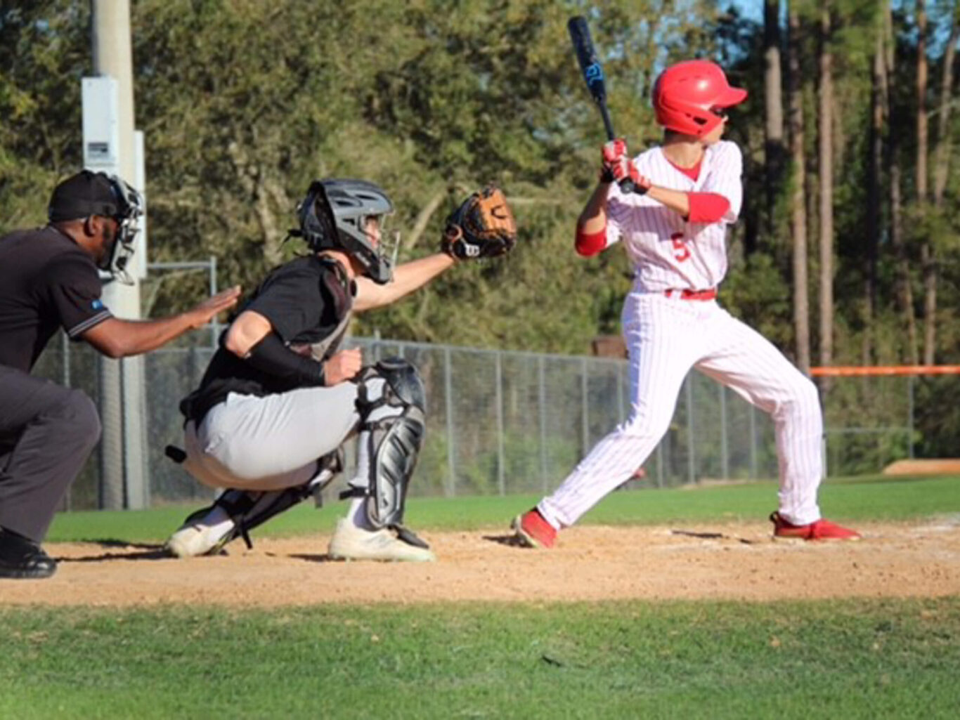 A baseball player swings at a ball during a game.