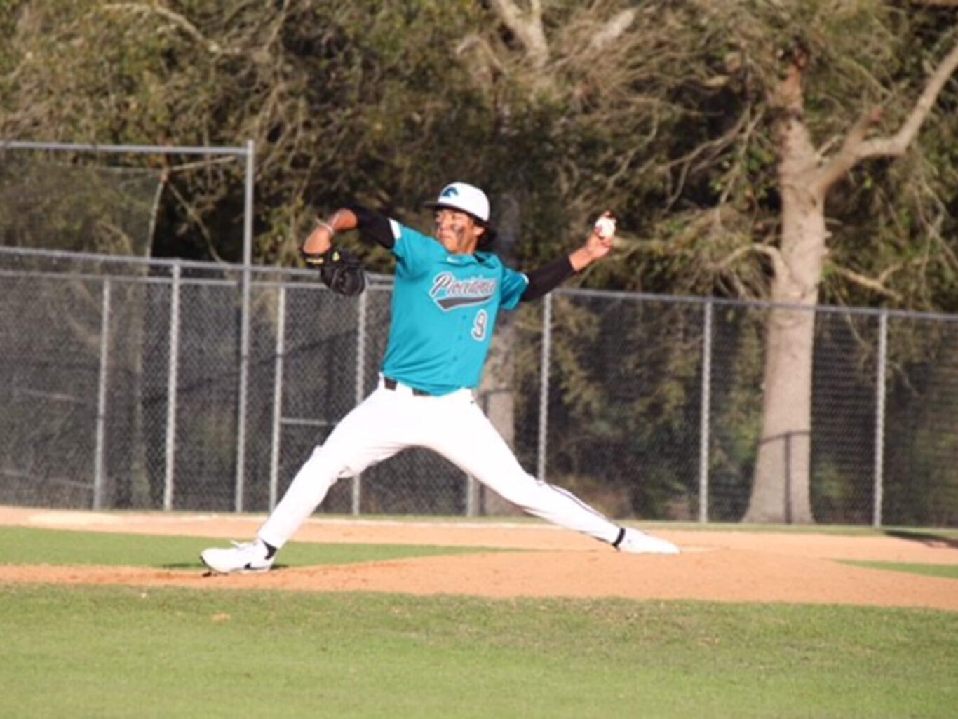 A baseball pitcher is throwing a ball on a baseball field.