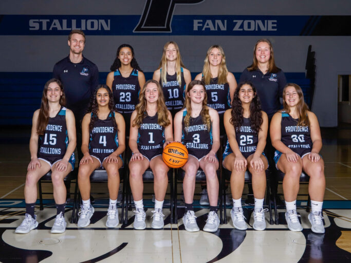 The girls basketball team is posing for a picture.