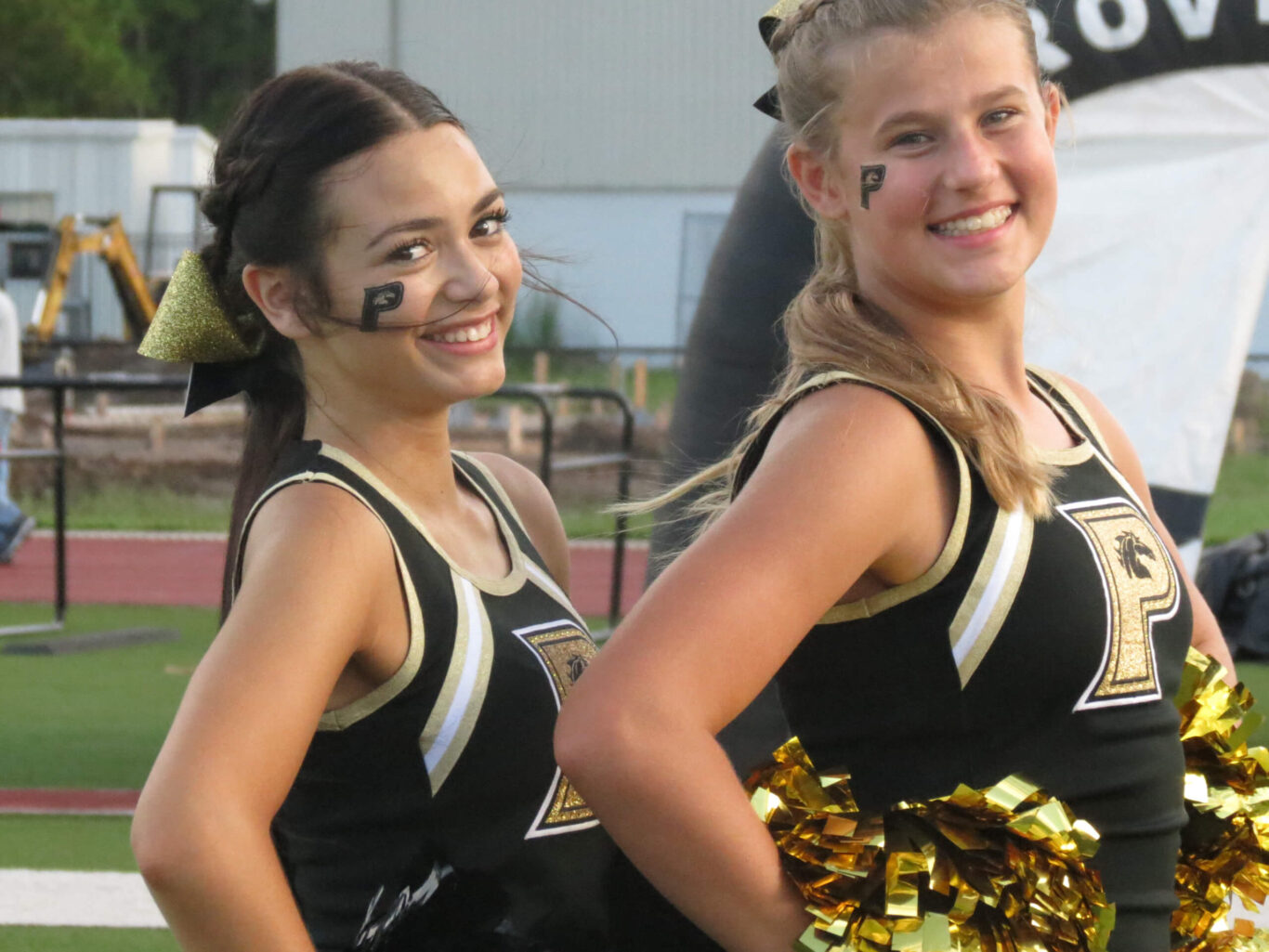 Two competitive cheerleaders posing for a picture.