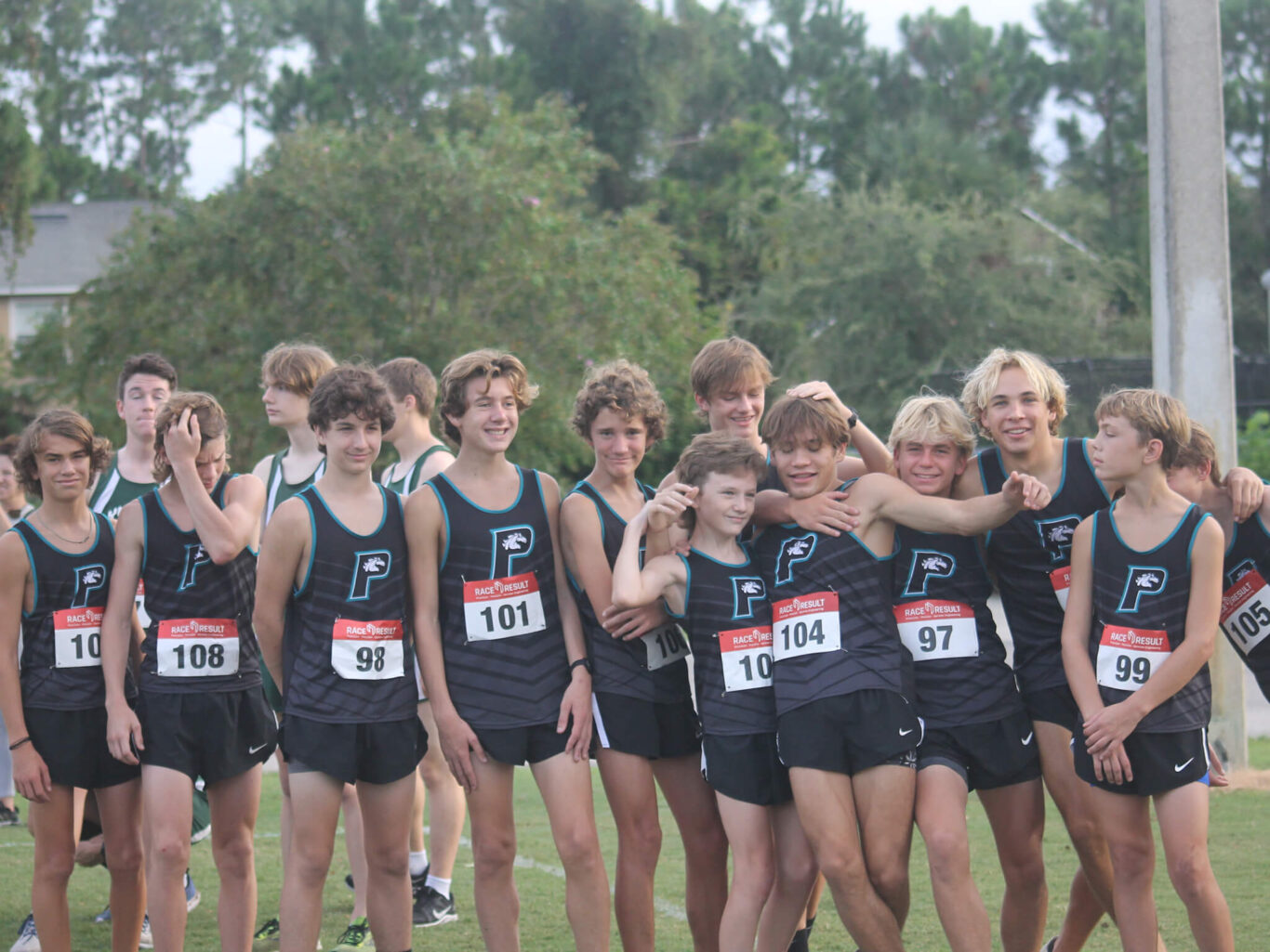 A group of boys from the cross country team posing for a picture.