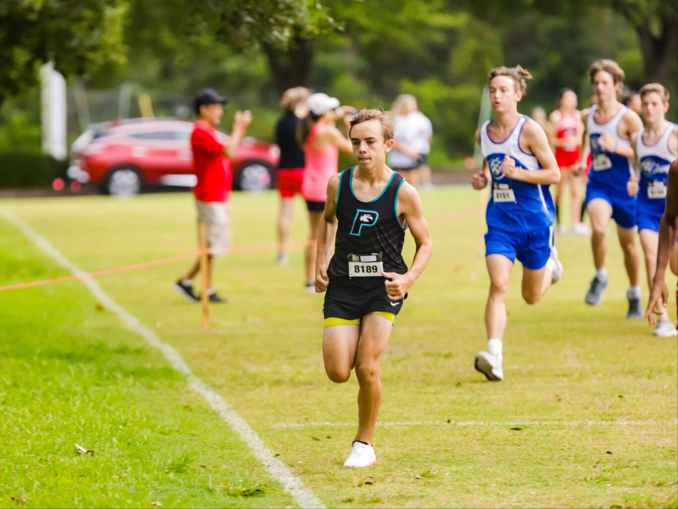 A group of boys competing in a cross country race.