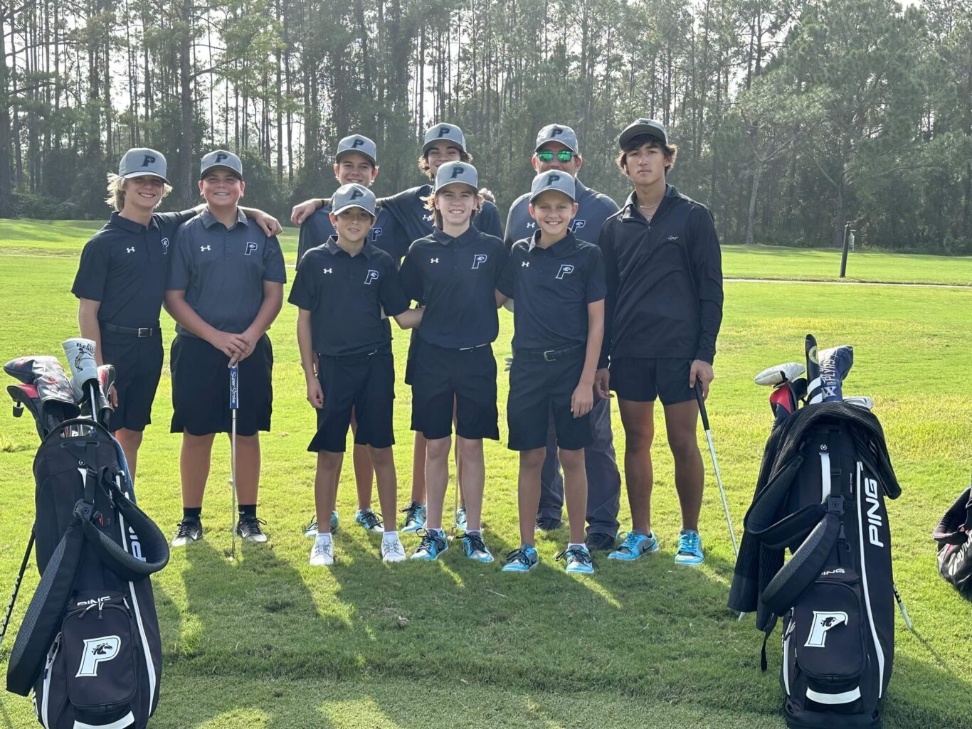 A group of boys posing for a golf picture.
