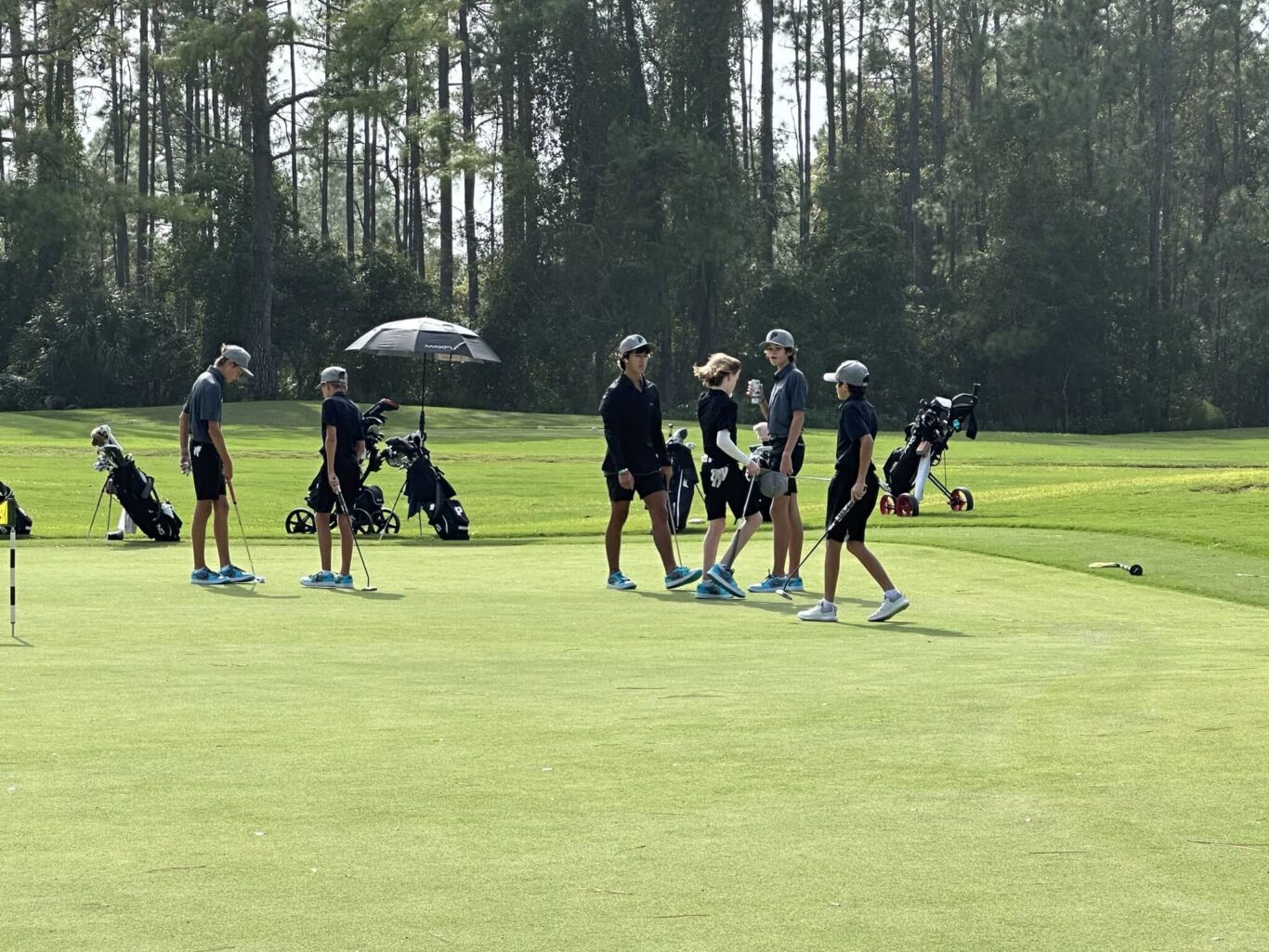A group of boys standing on a golf course.