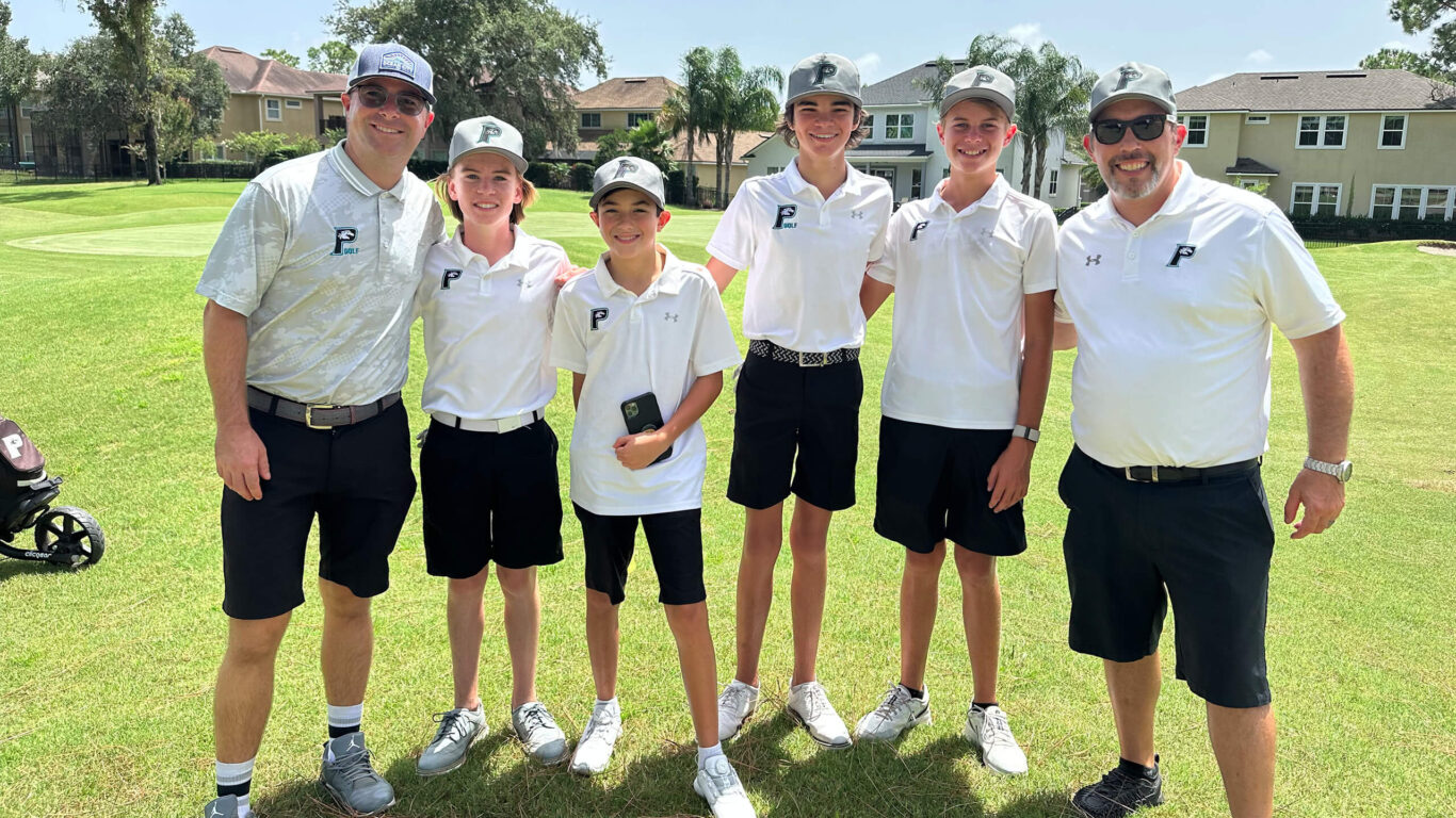 A group of Golf Boys posing for a photo on a golf course.