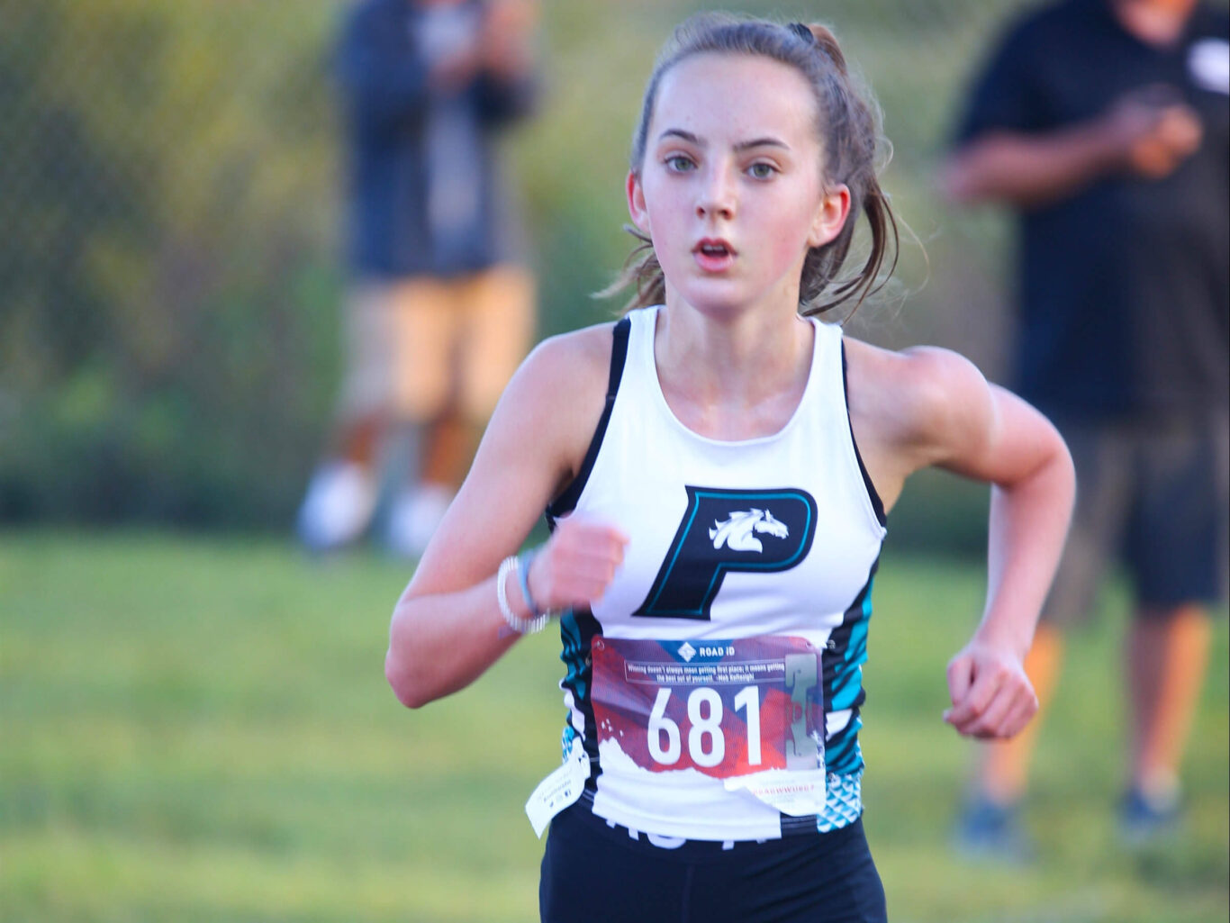 A young girl participating in a cross country race.