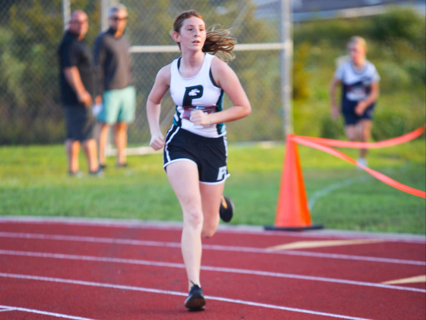 A Cross Country girl running on a track.