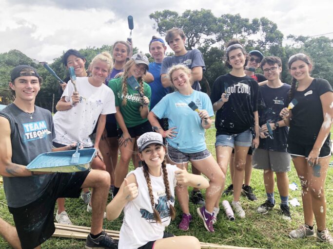 A group of young people in a community posing for a picture as part of a service project.