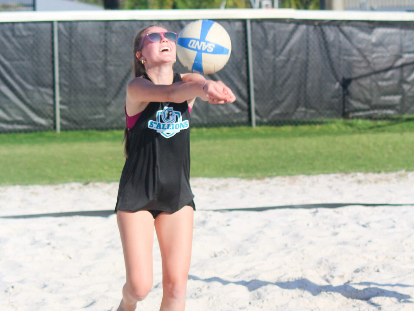 A girl is playing beach volleyball.