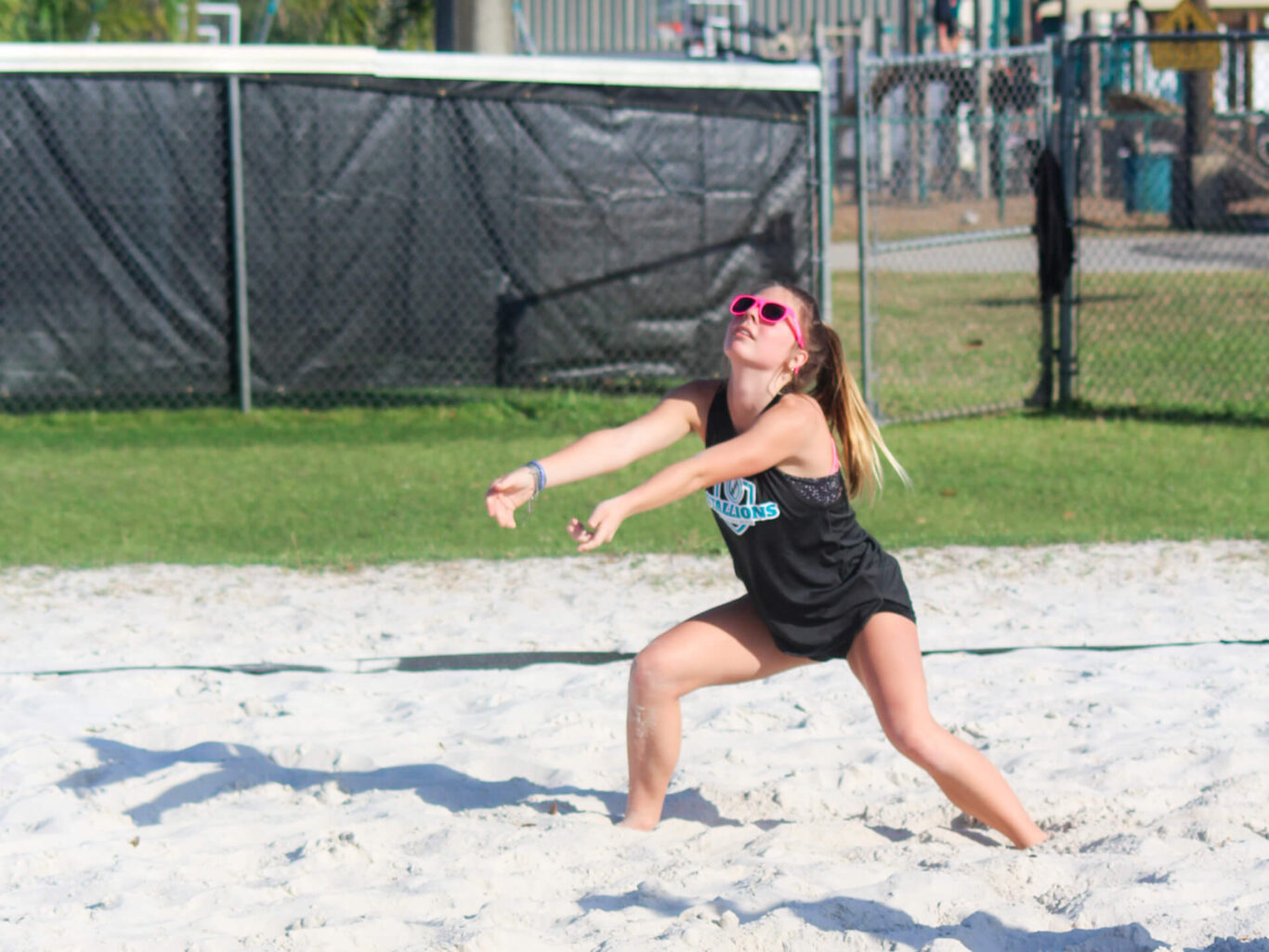 A woman enjoying a game of frisbee on the beach.